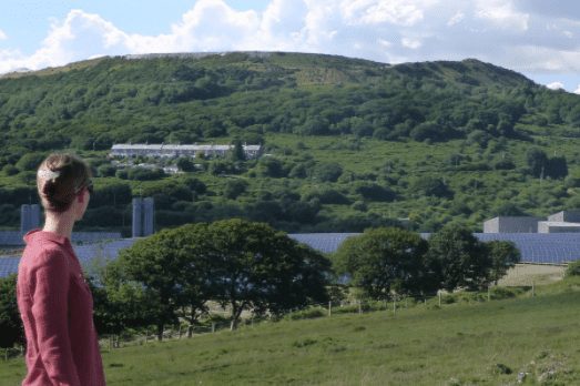 From South Dartmoor Community Energy Person looking out over hills and solar panels